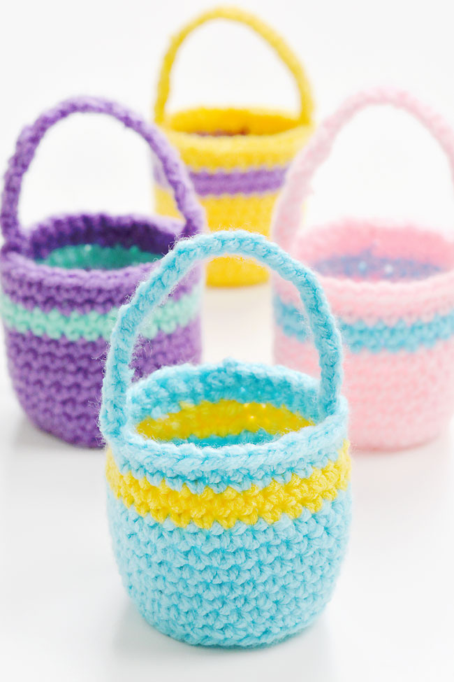 Group of colourful crochet Easter baskets made with a free PDF pattern