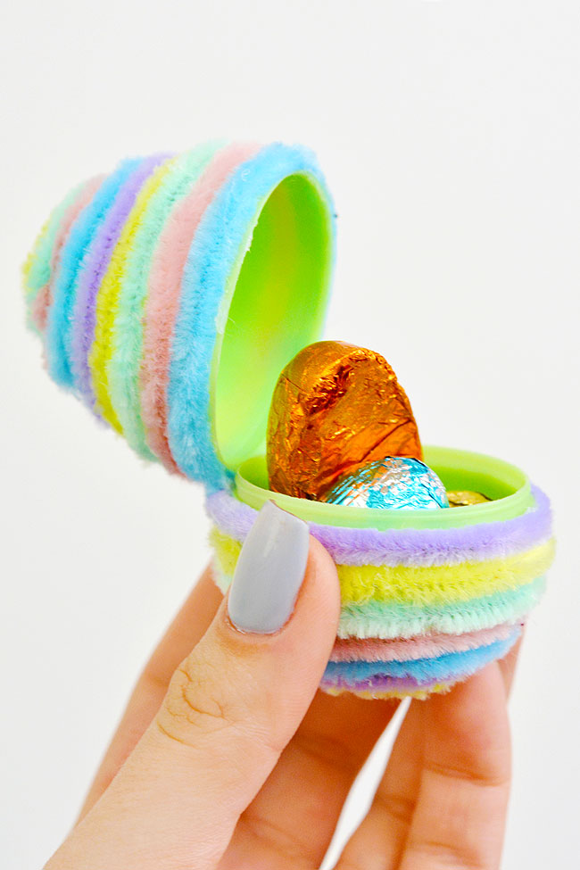An open fuzzy pipe cleaner covered egg showing hidden chocolate inside