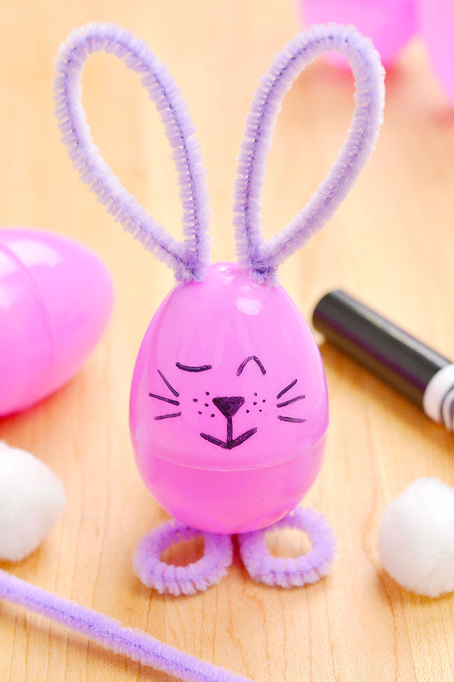 Closeup on a plastic egg bunny with supplies to make the craft