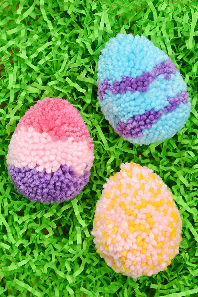 Cute pom pom Easter egg craft sitting in Easter grass