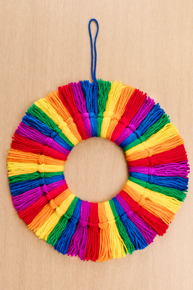 Tassel wreath made with yarn tassels on a wood background