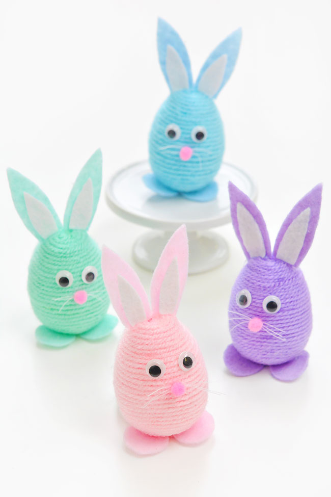 Group of colourful yarn wrapped Easter bunnies on a white background