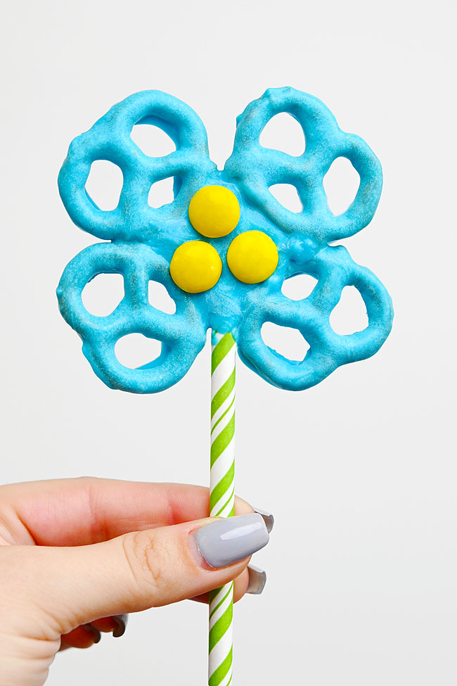 Closeup of a blue flower pretzel attached to a paper straw