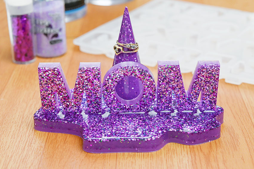 Closeup on a glittery purple nameplate and ring holder made from resin