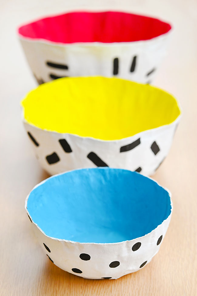 3 sizes of paper mache bowls painted red, yellow, and blue inside