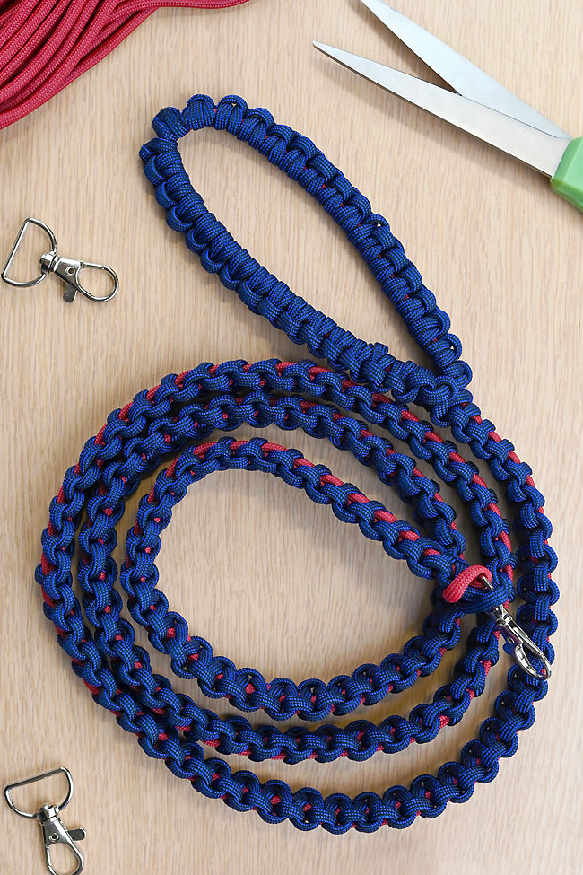 A paracord dog leash and accessories curled up on a wooden background