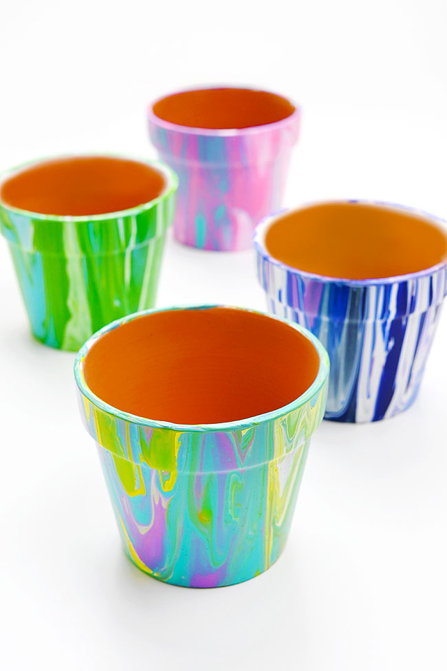 Colourful terracotta pots with marbled paint pour designs on the outside