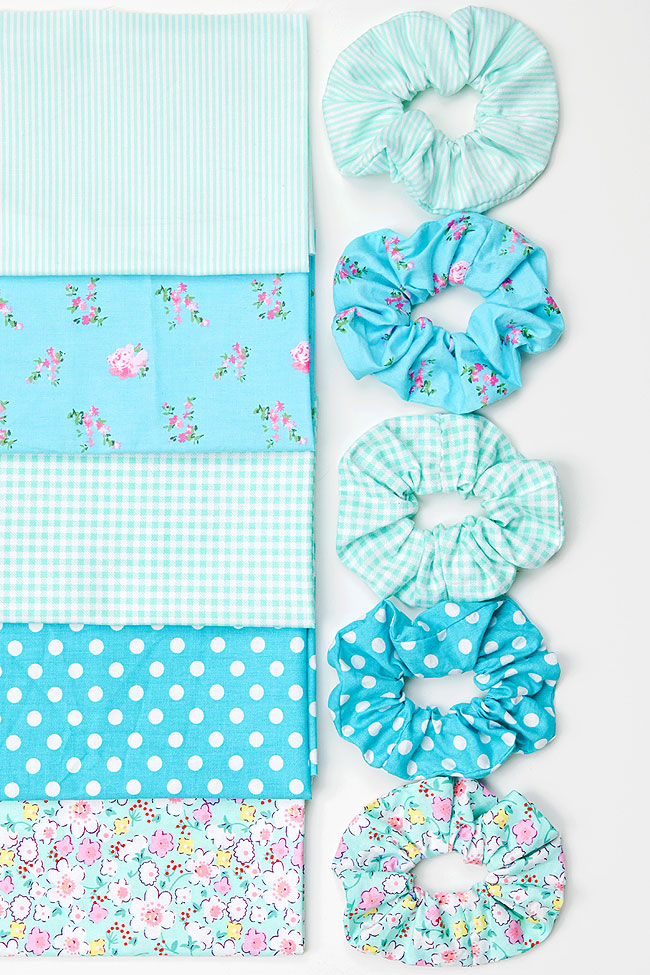 Homemade scrunchies beside their fabric