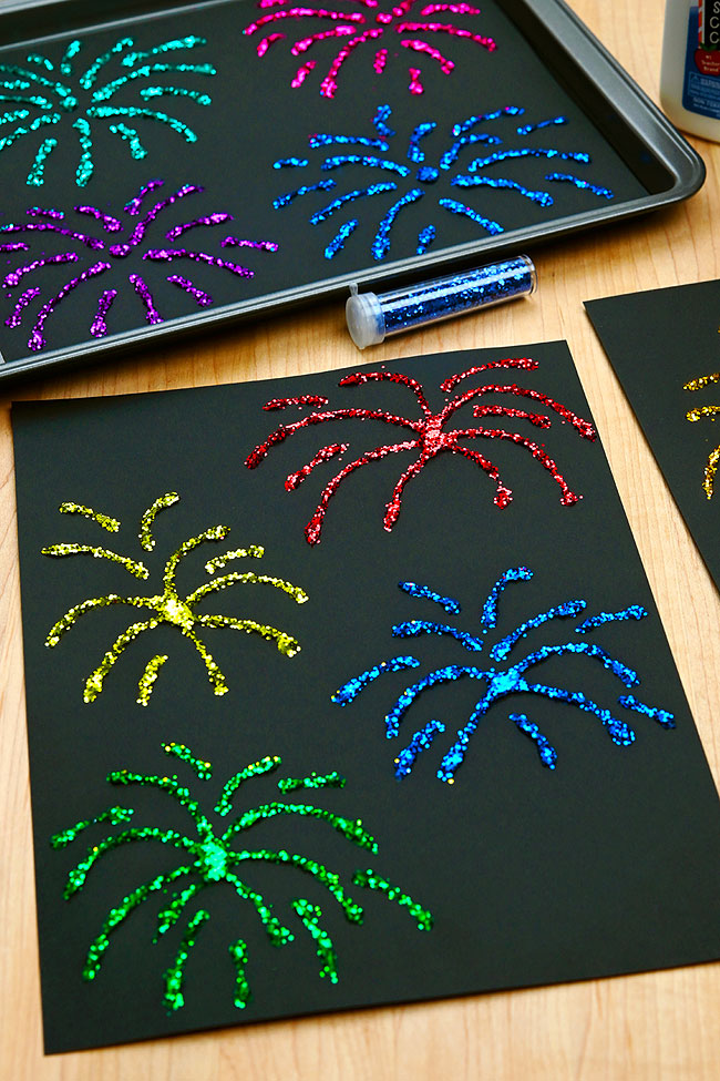 Glitter fireworks crafts sitting with glue and glitter tubes