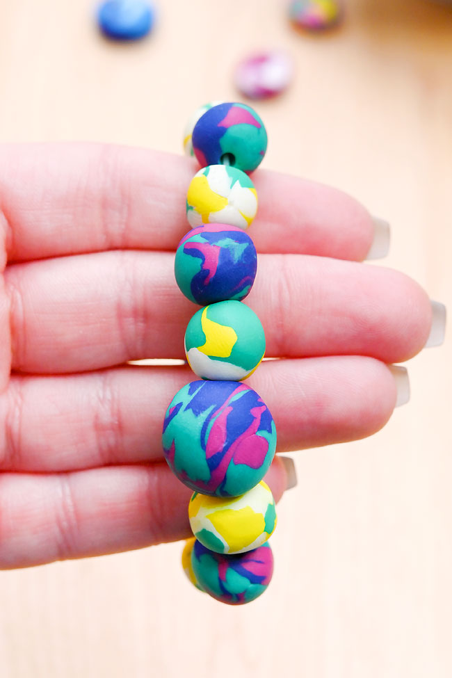 Different sizes and colours of round polymer clay beads on a string