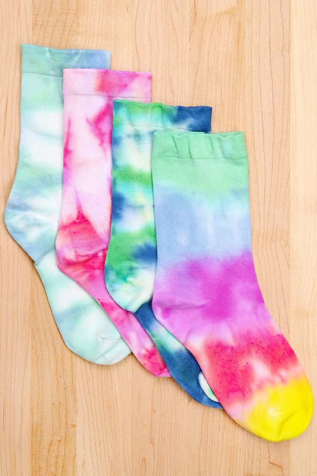 Pile of assorted tie dye socks on a wooden background