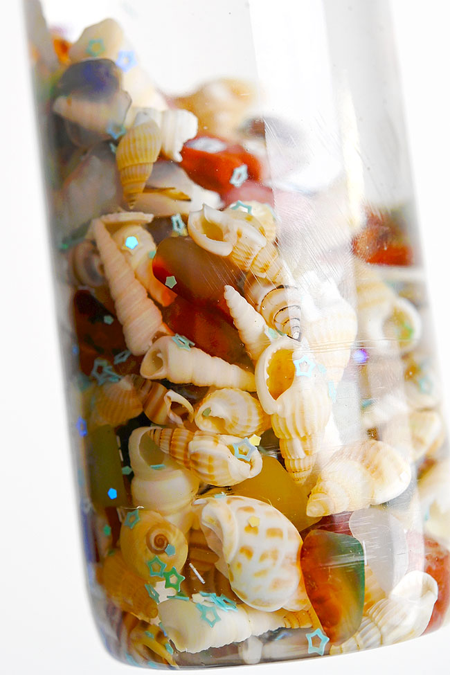 Closeup on a seashell and rocks ocean sensory bottle
