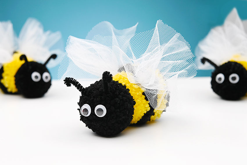 Super cute pom pom bee toys made with yarn, tulle, googly eyes, and pipe cleaners