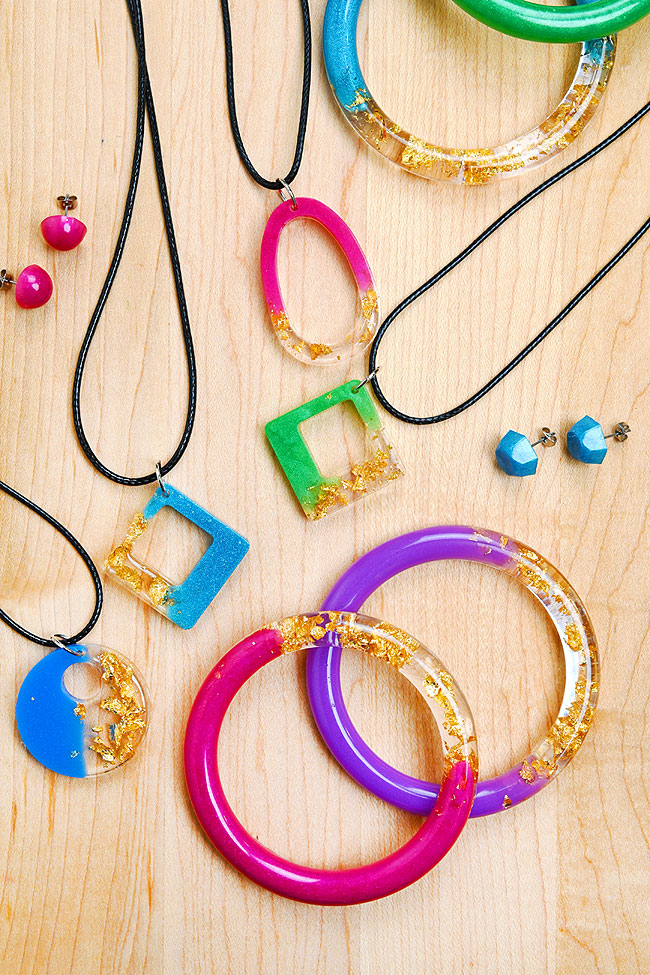 Resin bracelets, earrings, and pendants on a wooden background