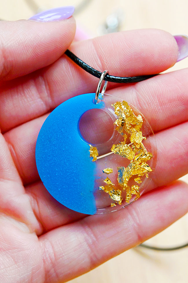 Holding a resin necklace made with mica powder and gold foil