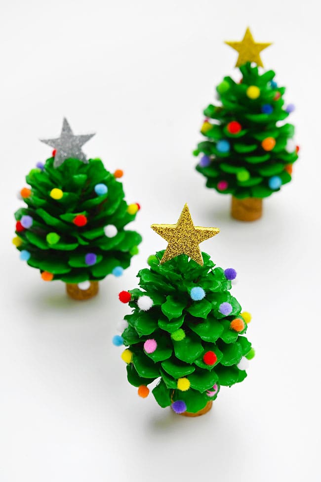 Group of DIY pinecone Christmas trees on a white background