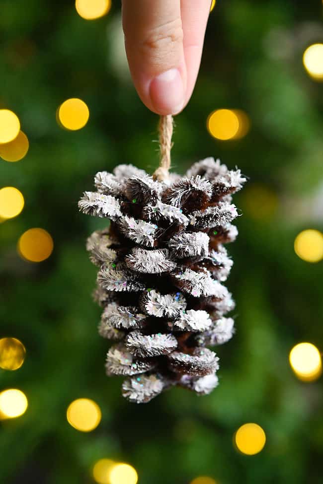 DIY Pipe Cleaner Pine Cone Holding a glittery DIY pipe cleaner pine cone ornament
