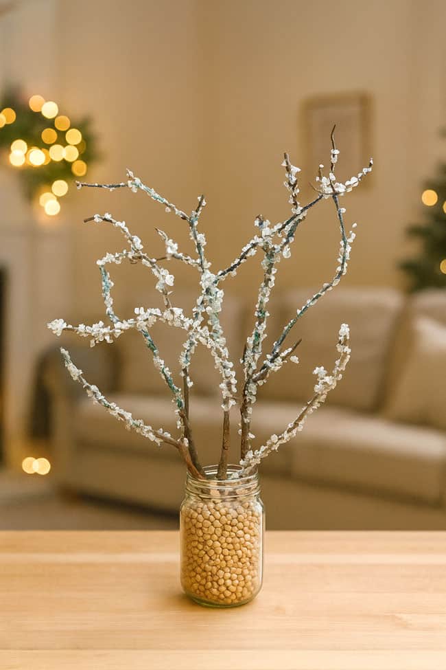 DIY Snowy Branches with Vase Filler Snowy branches in a jar on the living room table