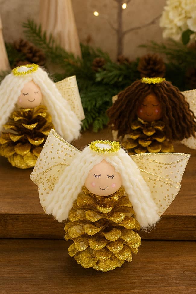 Pinecone Angel Craft Pinecone angel crafts in front of a holiday display
