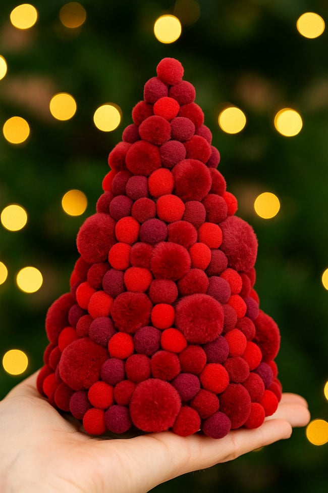 Easy Pom Pom Tree Holiday Craft Holding a dark red pom pom tree