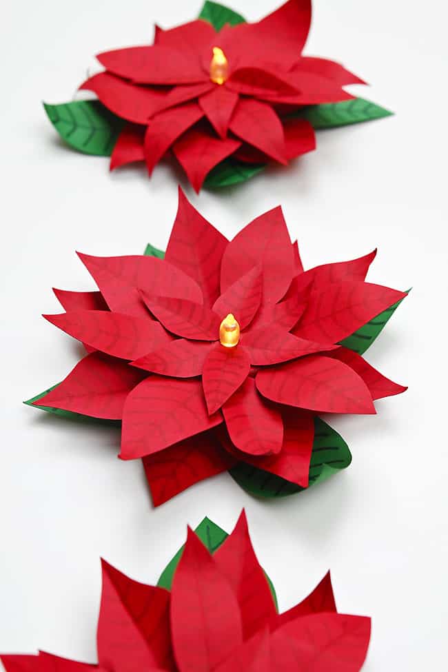 Poinsettia LED Tea Light Craft Paper poinsettia flower candles on a white background