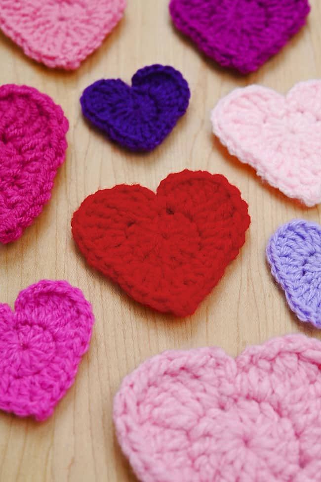 Crochet Small Heart Closeup on small crochet hearts sitting on a wood background