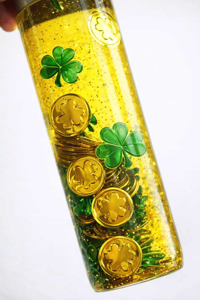 DIY St Patrick's Day Sensory Play Closeup on a DIY St. Patrick's Day sensory bottle with shamrocks and leprechaun gold