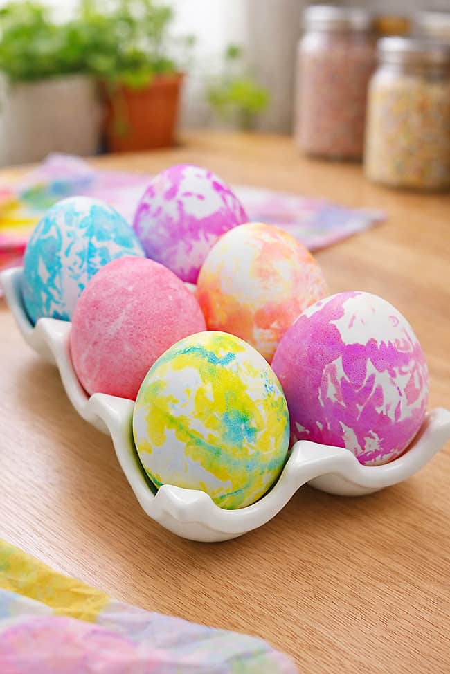 Dye Eggs with Tissue Paper Colorful Easter eggs sitting in a ceramic egg holder