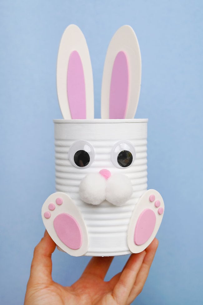 Easter Bunny Tin Can Craft Holding a cute Easter bunny craft in front of a blue background