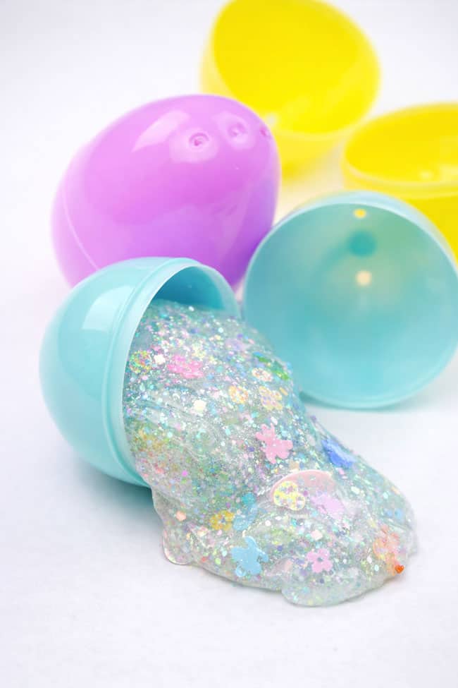 Clear glue Easter slime with glitter and confetti coming out of a plastic Easter egg
