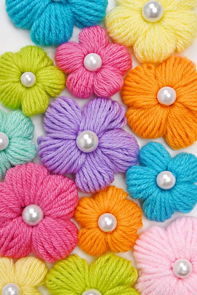 Colourful flowers made with yarn and a pearl bead