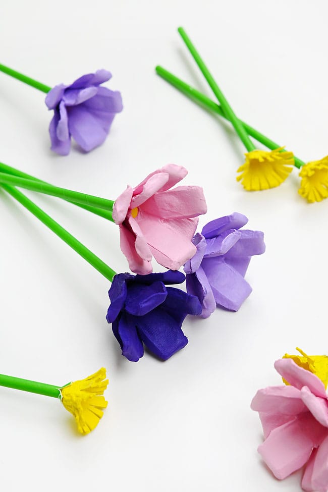 Egg Carton Flowers for Mother's Day Cute pink, purple, and yellow flowers made with egg carton pieces and a paper straw