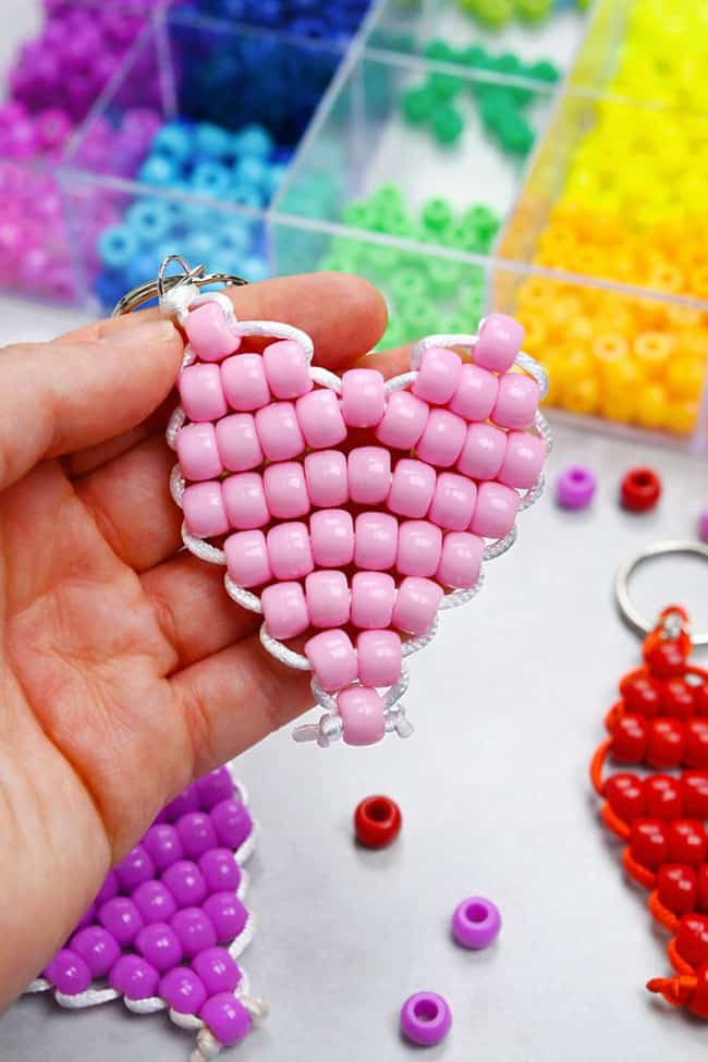 Holding a light pink pony bead heart