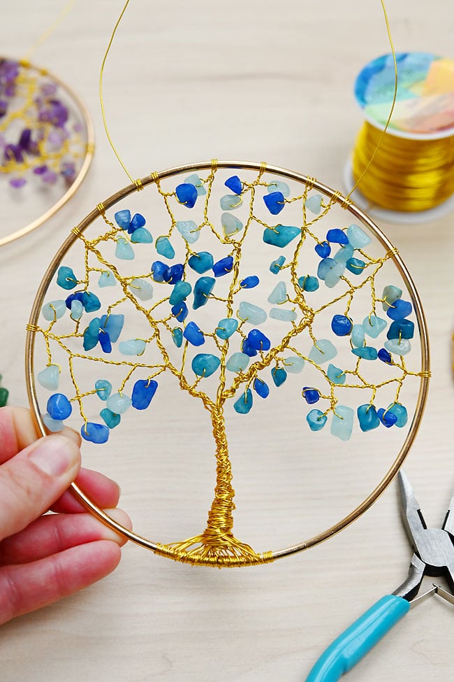 Holding a DIY tree of life suncatcher