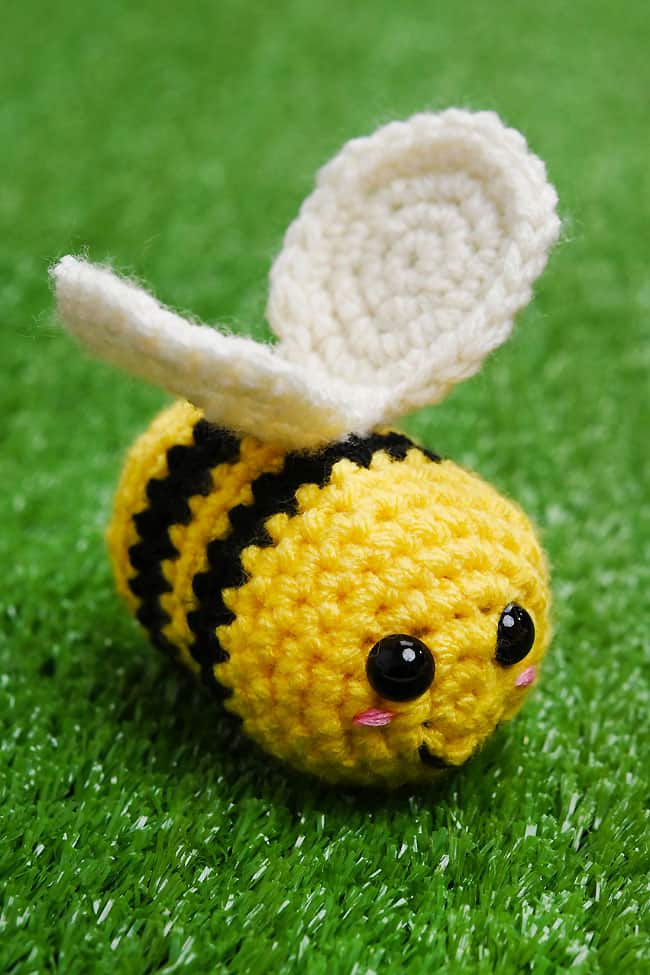 Crochet Bee Pattern Plush crochet bee sitting in fake grass