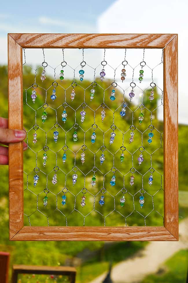 DIY Chicken Wire Suncatcher Holding a chicken wire suncatcher with pastel beads