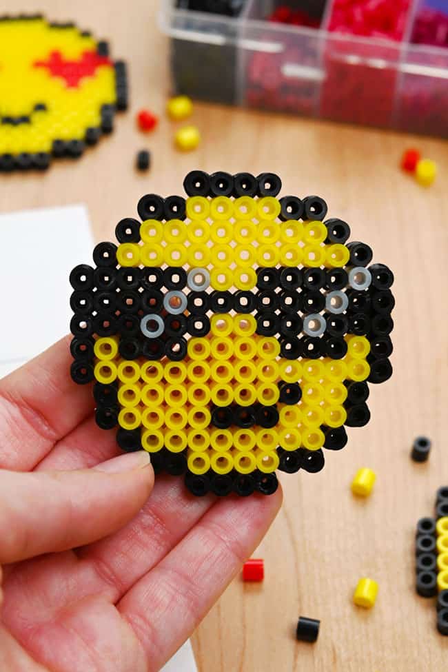 Sunglasses Emoji Perler Beads Holding a Perler bead design featuring a sunglasses face emoji