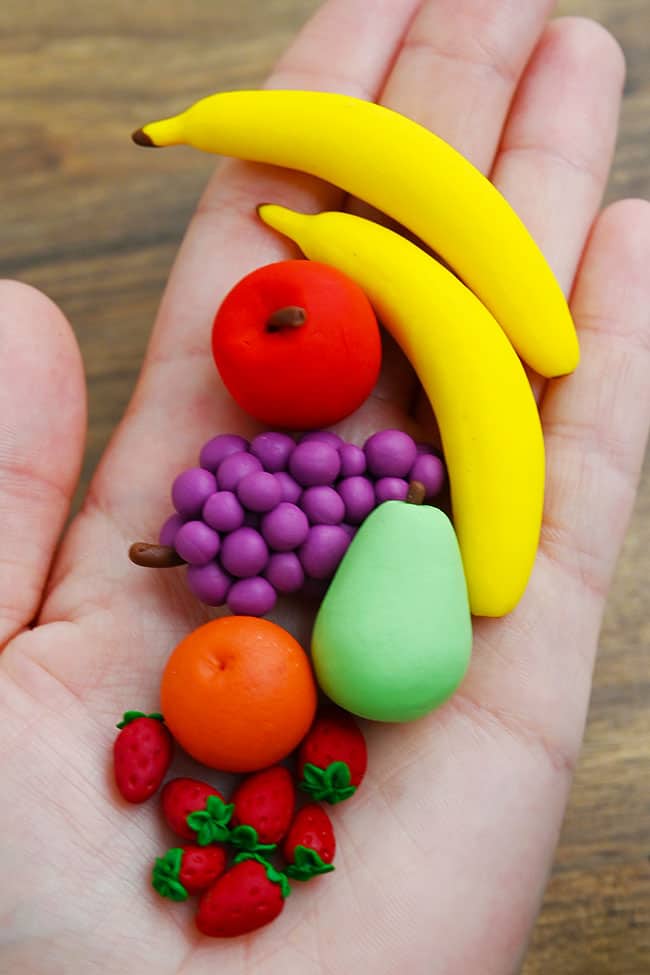 Clay Fruit Holding adorable mini clay fruit in hand