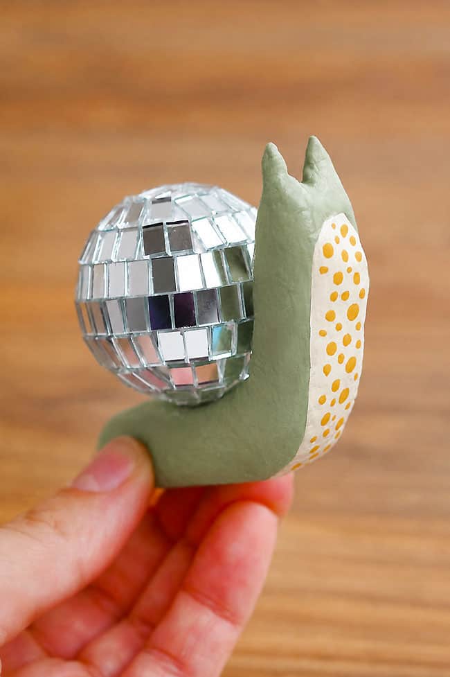 How to Make a Disco Snail Holding a green disco snail with yellow spots