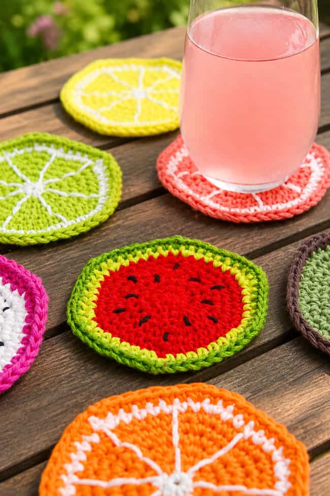 Crochet Fruit Coasters Colorful crochet fruit coasters on a picnic table