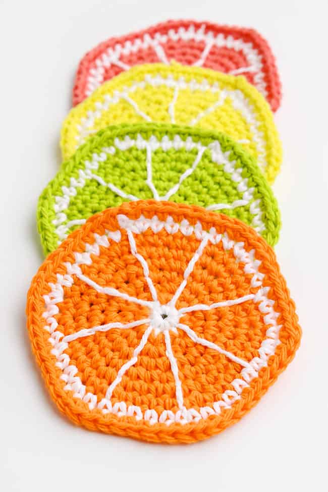 Fruit Crochet Coasters Citrus fruit slices crochet coasters on a white background