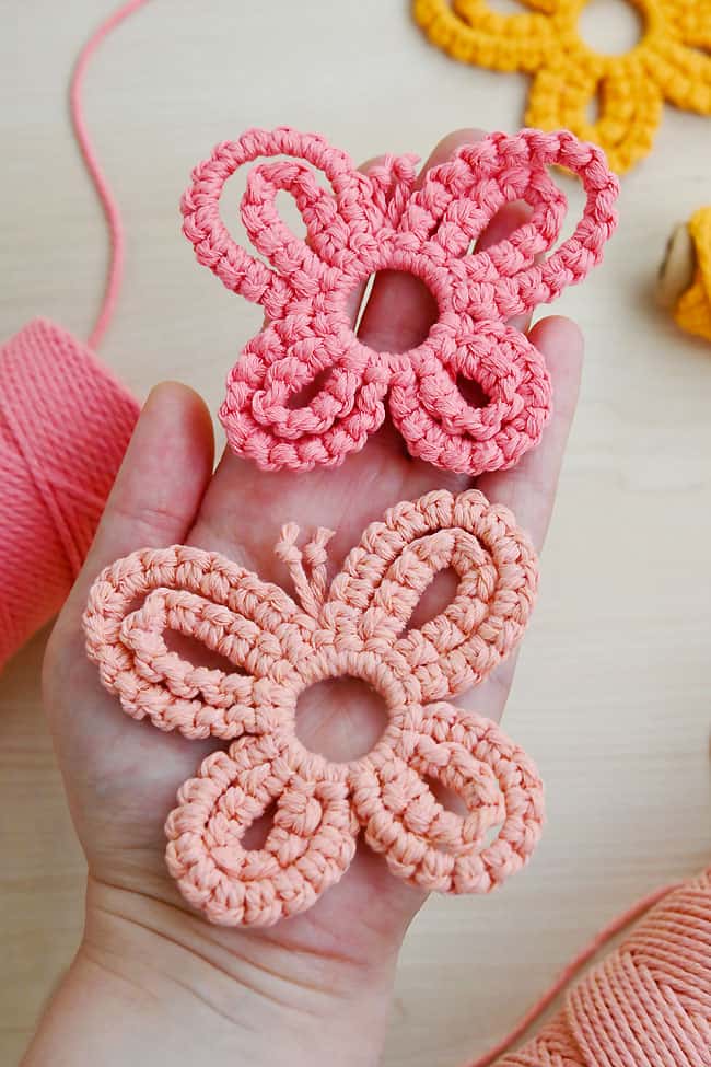 Macrame Butterfly Tutorial Holding pink macrame butterfly decorations