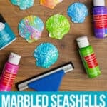 Decoupaging marbled tissue paper on a seashell