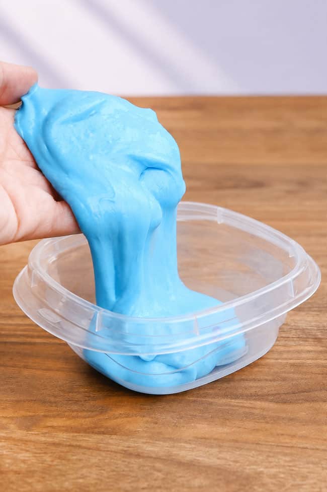 Store Slime Adding blue slime to a plastic food container