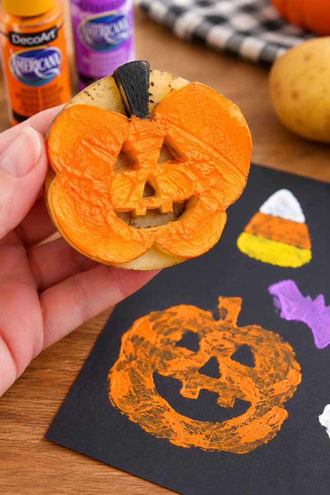 Halloween Potato Stamps Using a jack-o-lantern potato stamp for Halloween